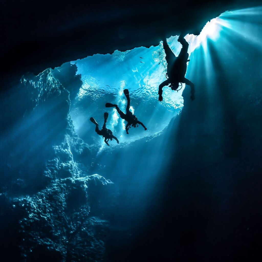 Three divers in an underwater cave
