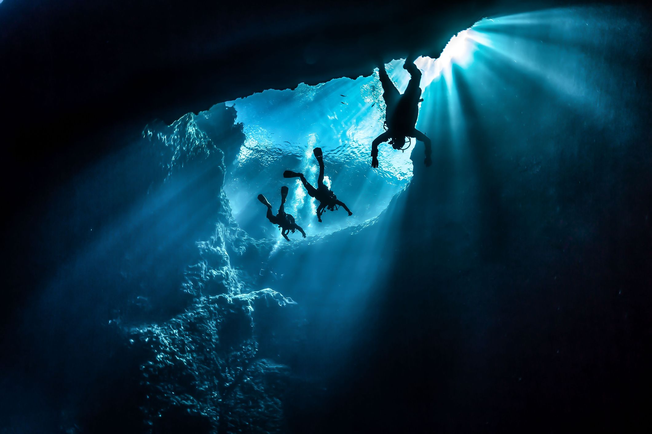 Three divers in an underwater cave