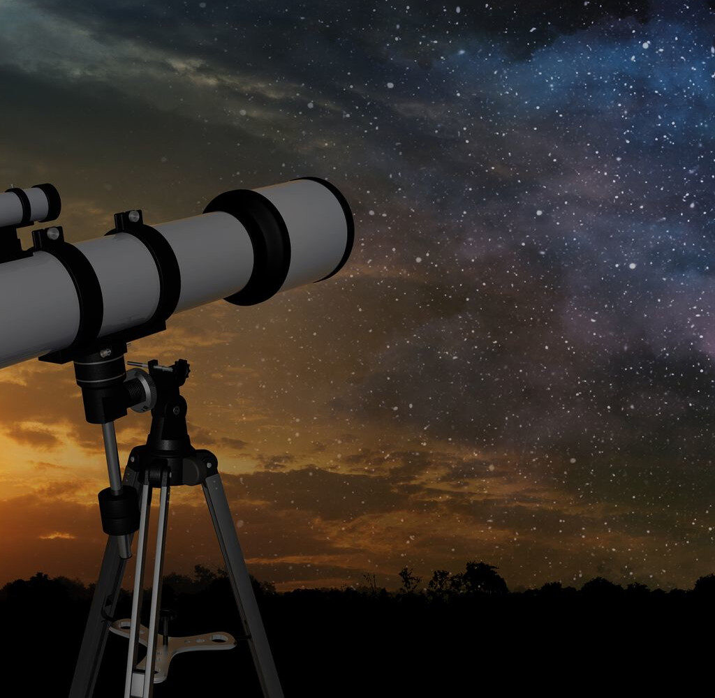A telescope at sunset looking into a night sky